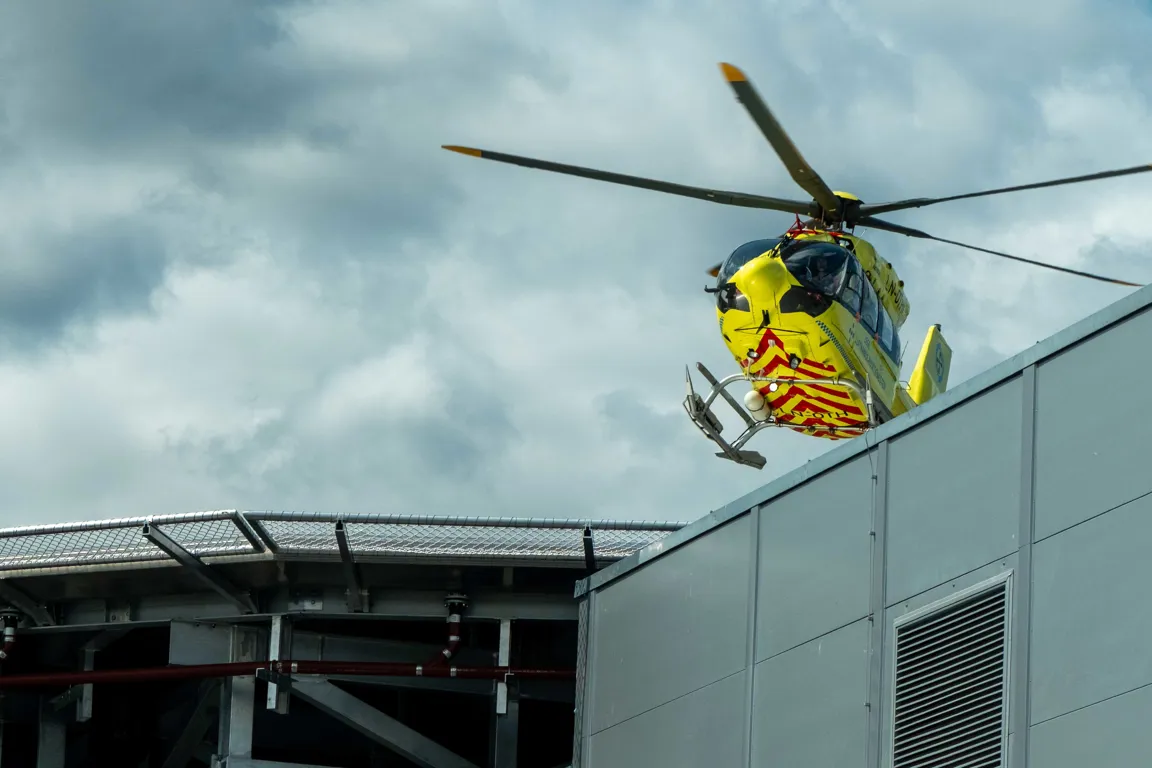 Et gult helikopter som flyr over en bygning