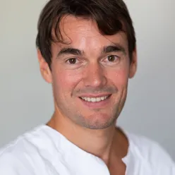 En mann som smiler til kameraet