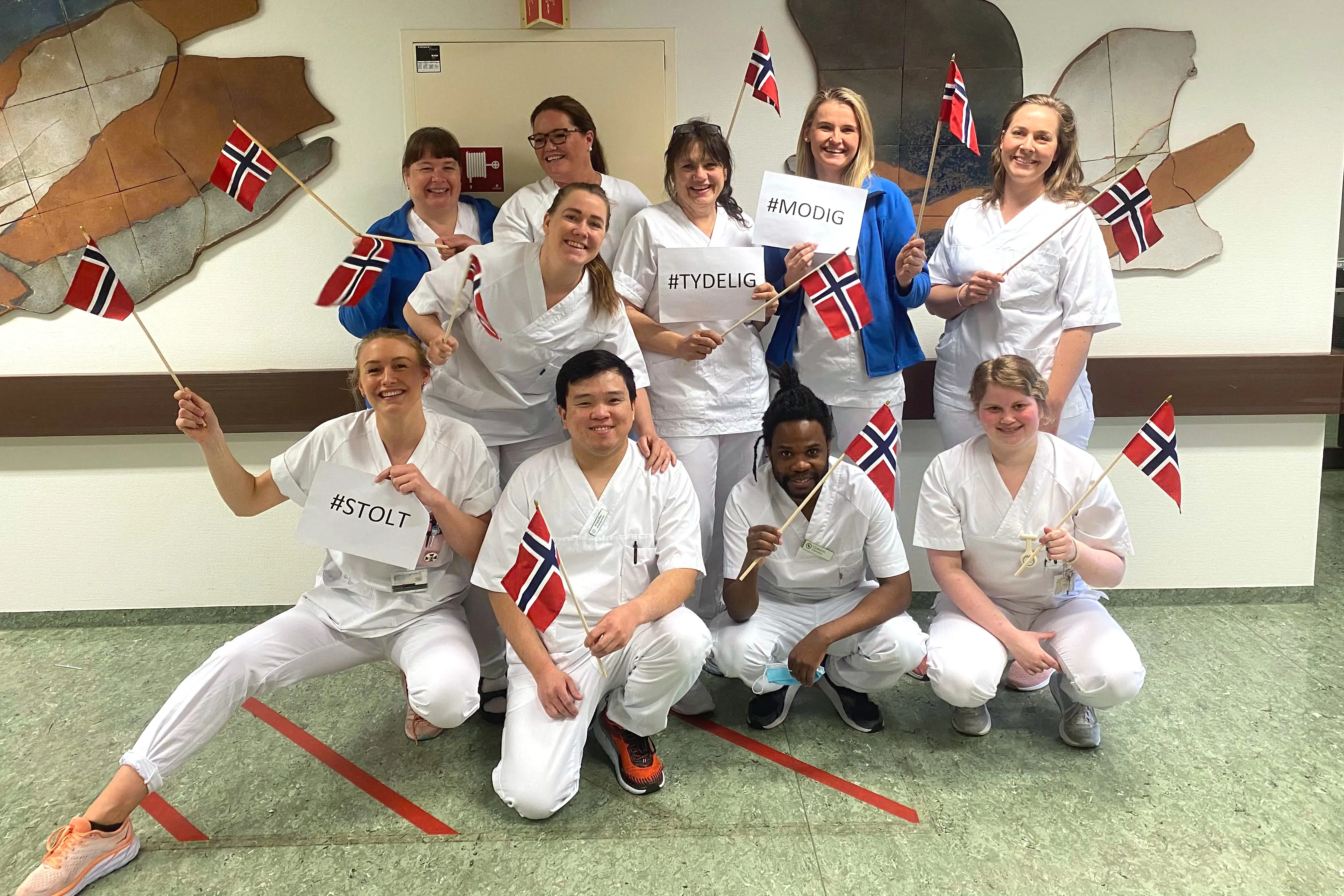 Sykepleiere på ortopedisk avdeling på Bærum sykehus vifter med flagg til ære for den internasjonale sykepleierdagen.