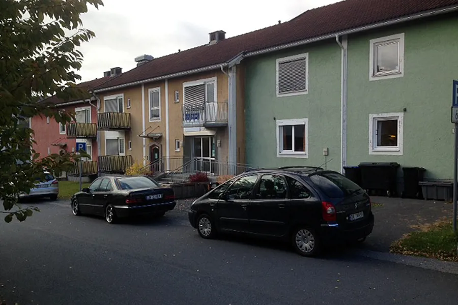 Et par biler parkert foran et hus
