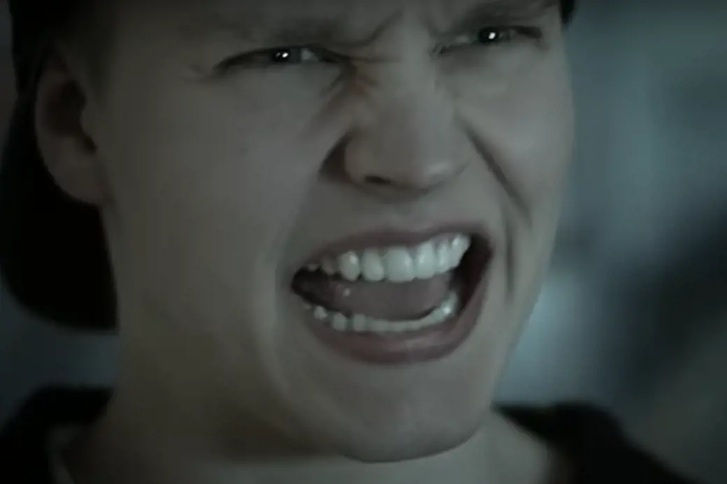 Bilde fra filmen som viser nærbilde av fjeset til en hvit, sint kvinne med åpen munn.