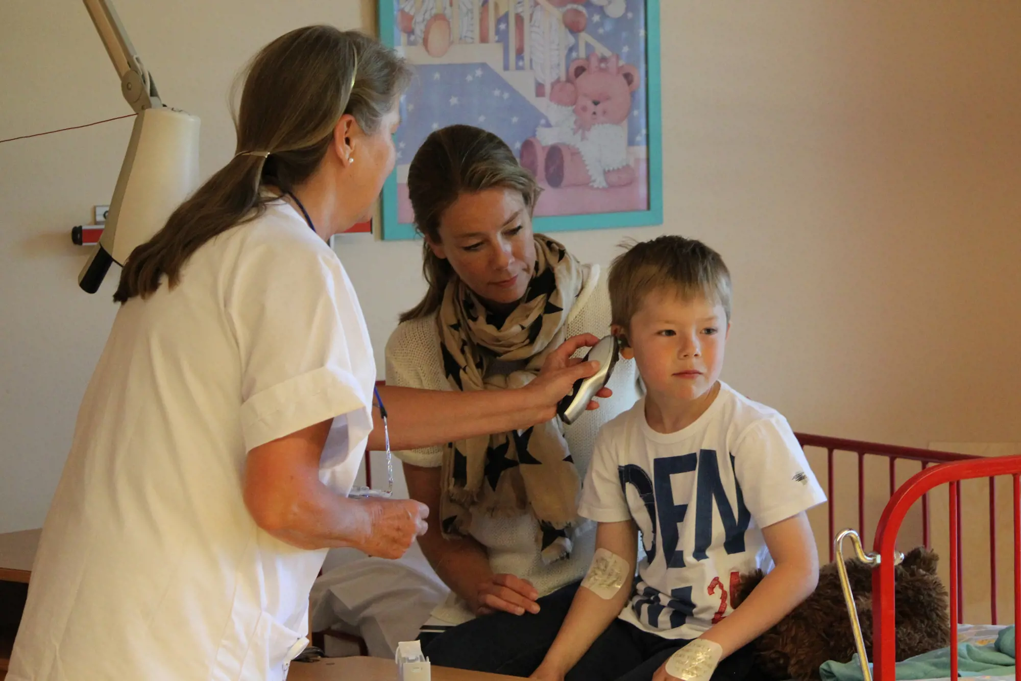 Sykepleieren måler temperaturen på Nicolai i et øre.