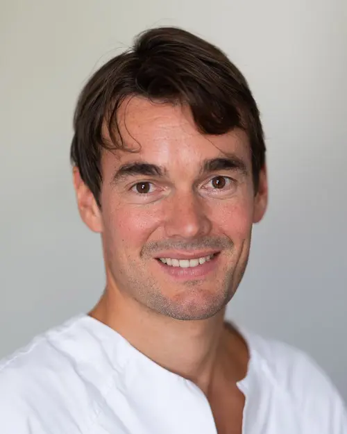 En mann som smiler til kameraet