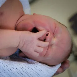 En babyhånd som holder en babys fot
