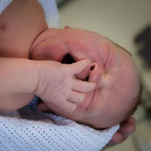 En babyhånd som holder en babys fot