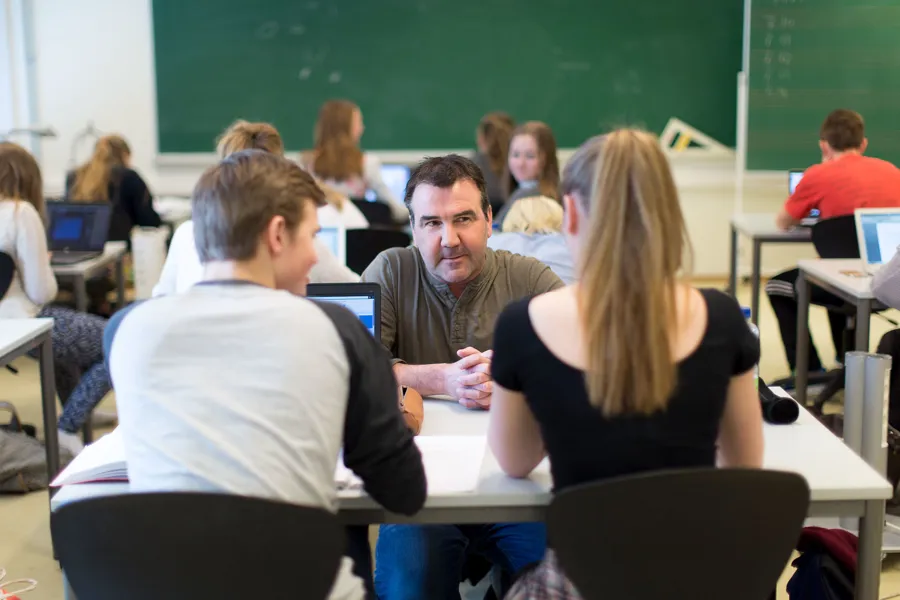 En gruppe mennesker som sitter i et klasserom