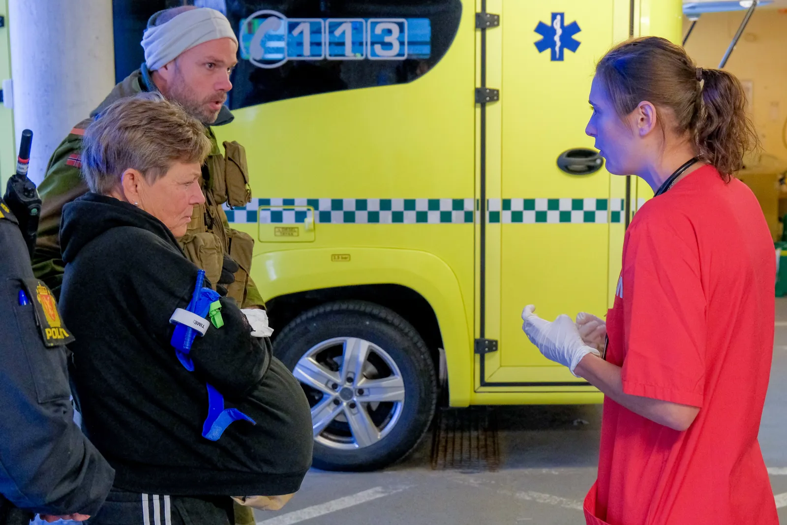 En gruppe mennesker som står ved siden av en gul lastebil