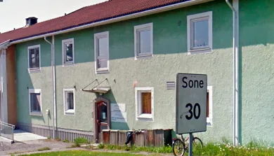 Et hus med et skilt foran