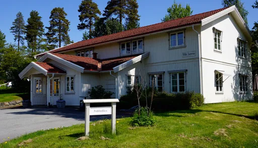 Et hus med plen og trær