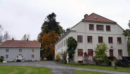 En hvit bygning med rødt tak