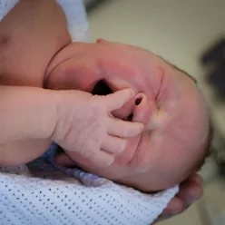 En babyhånd som holder en babys fot